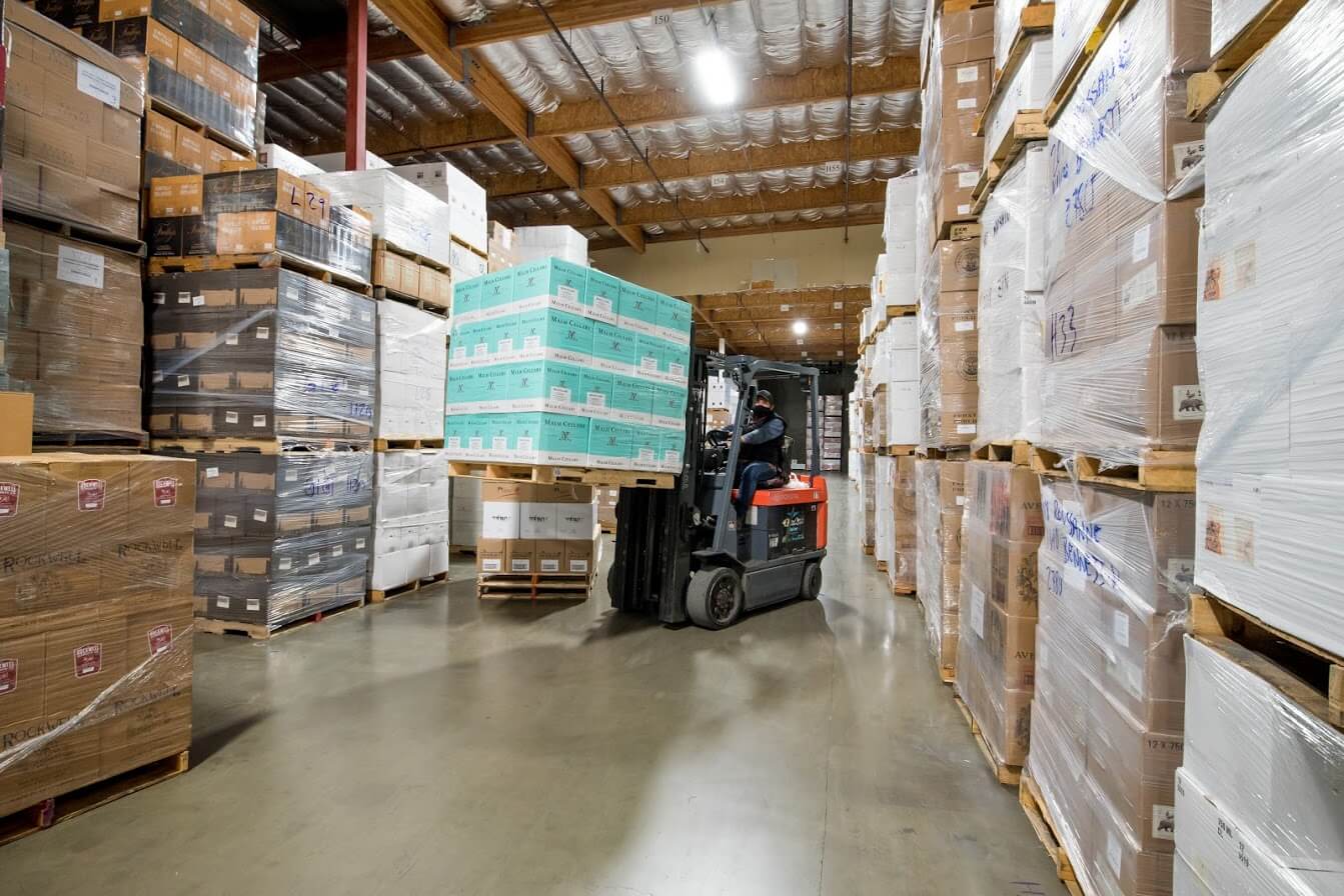 Forklift raising a pallet of wine cases into the racks.